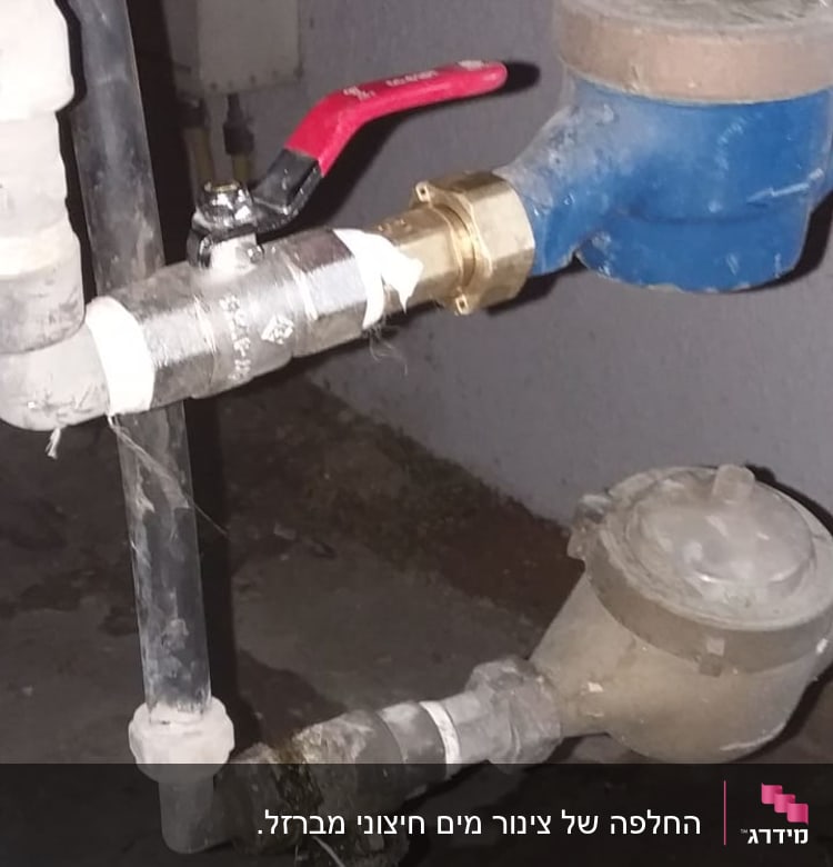 צינור מים עם ברז אדום ומד מים כחול
